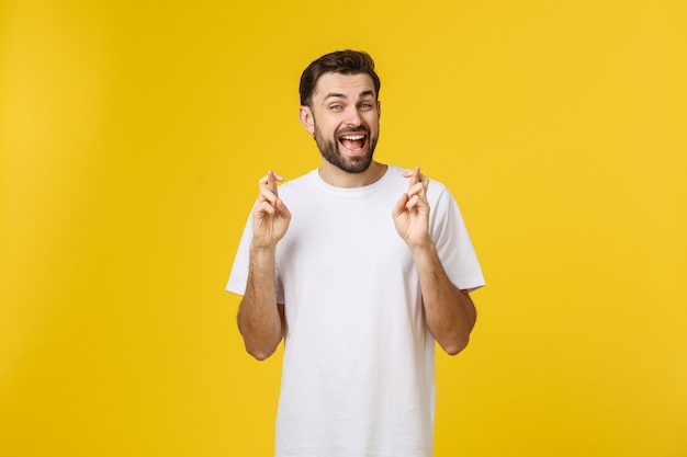 Foto joven pidiendo un deseo aislado en amarillo