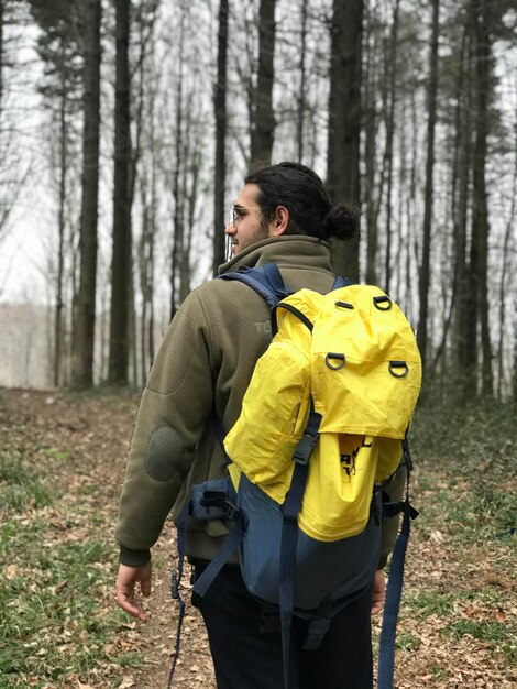 Foto joven de pie en el bosque