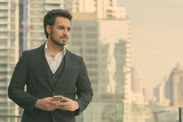 Foto joven de pie frente a los edificios de oficinas