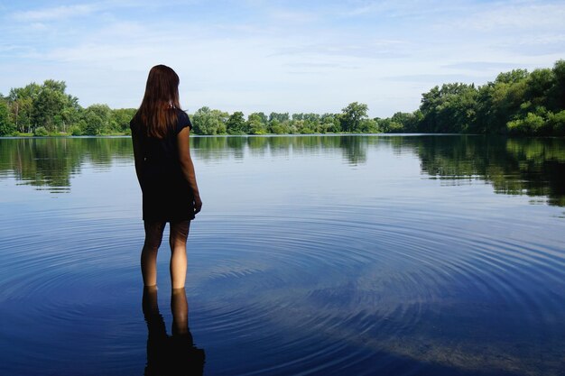 Foto joven de pie en el lago