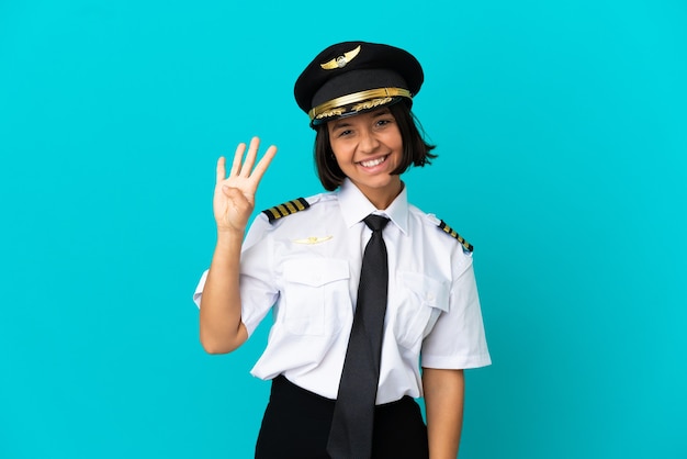 Joven piloto de avión sobre fondo azul aislado feliz y contando cuatro con los dedos