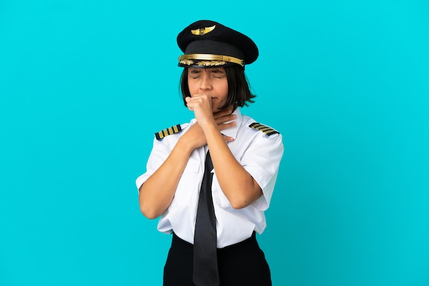 Joven piloto de avión sobre fondo azul aislado tosiendo mucho