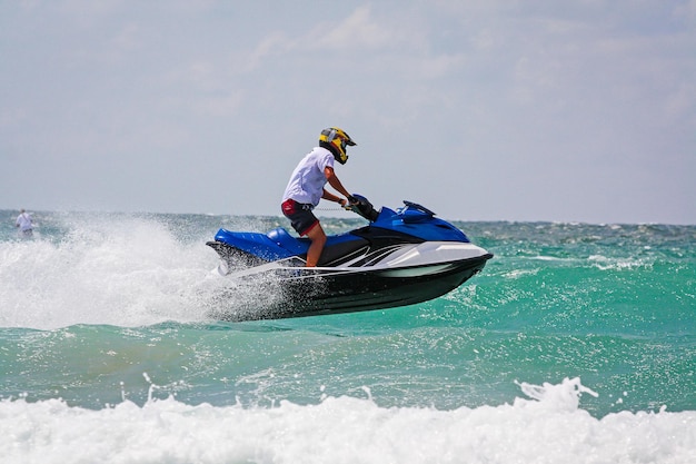Un joven piloto profesional de jet ski realiza muchos trucos en las olas