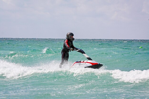 Foto joven piloto profesional de motos acuáticas realiza muchos trucos en las olas