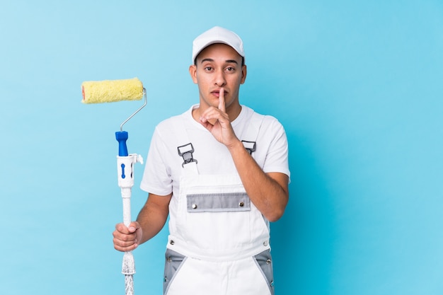 Joven pintor profesional latino guardando un secreto o pidiendo silencio.