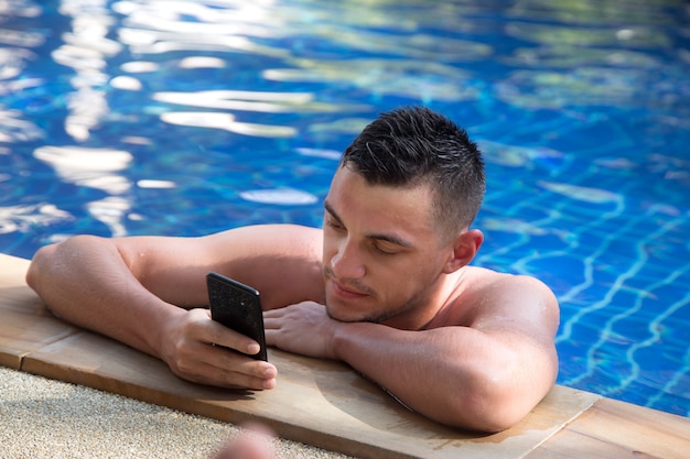 joven en la piscina con un teléfono