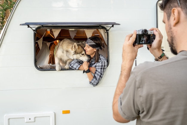 Joven pohotographing a su esposa y perro husky