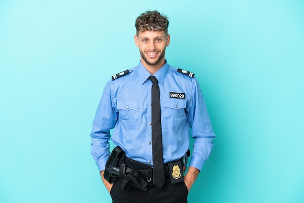 Joven policía rubio hombre aislado blanco sobre fondo azul riendo