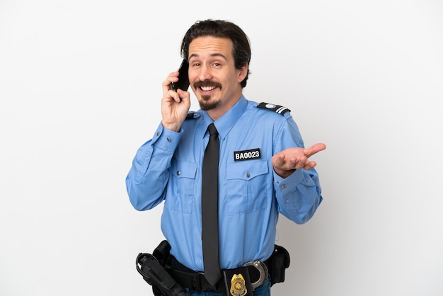 Joven policía sobre fondo blanco aislado manteniendo una conversación con el teléfono móvil con alguien
