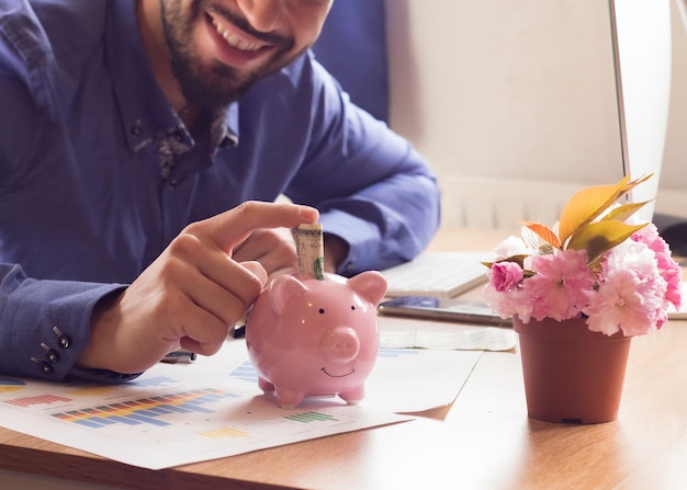 Joven poniendo dinero a cuestas, freelance, trabajo desde casa salario