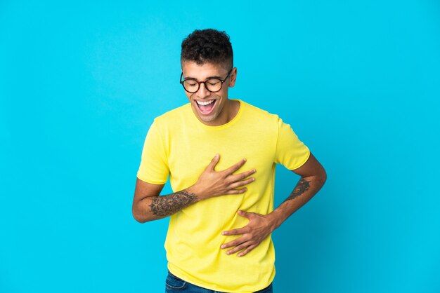 Joven posando aislado contra la pared en blanco