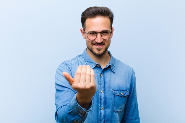 un joven posando mientras te da la bienvenida