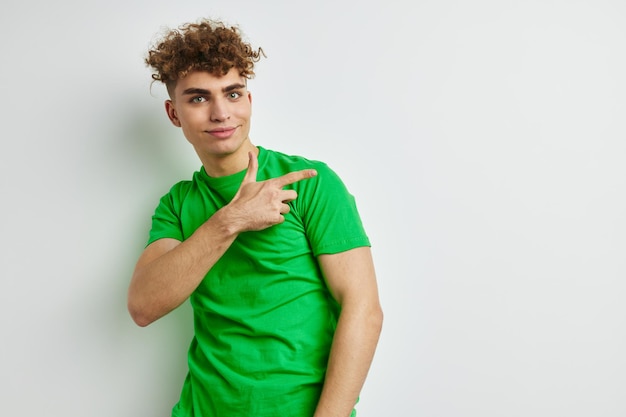 Joven posando sobre un fondo blanco en una camiseta verde