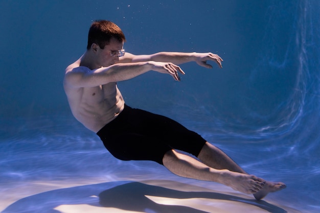 Foto joven posando sumergido bajo el agua