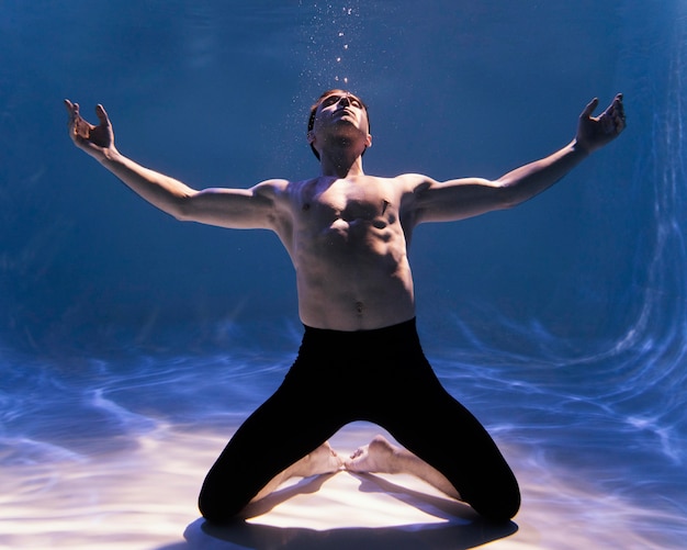 Foto joven posando sumergido bajo el agua