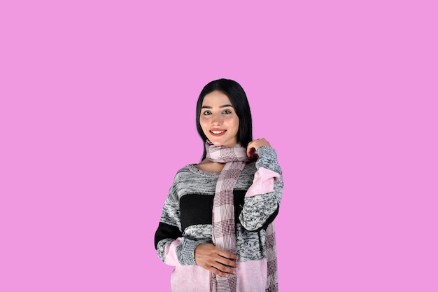 Joven pose frontal vistiendo ropa de invierno con una sonrisa sobre fondo rosa modelo paquistaní indio