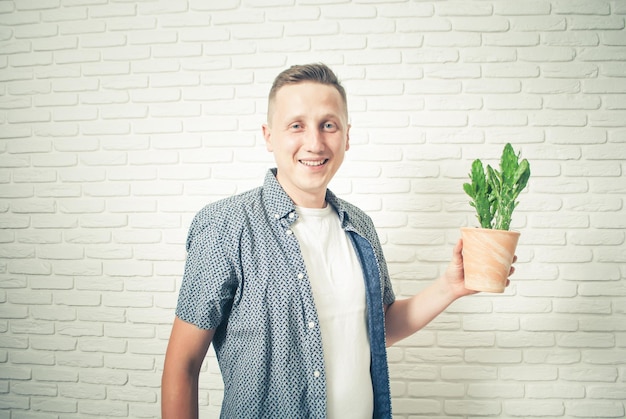 joven positivo sosteniendo un cactus