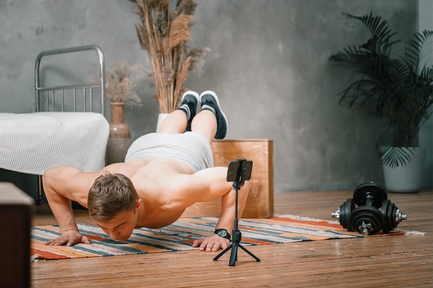 El joven practica deporte en casa.