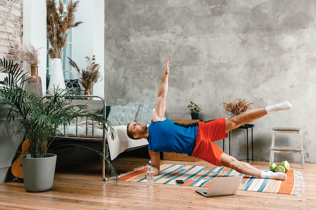 El joven practica deporte en casa.