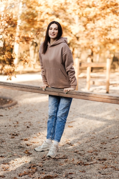 Una joven practica deportes en el parque en el otoño.