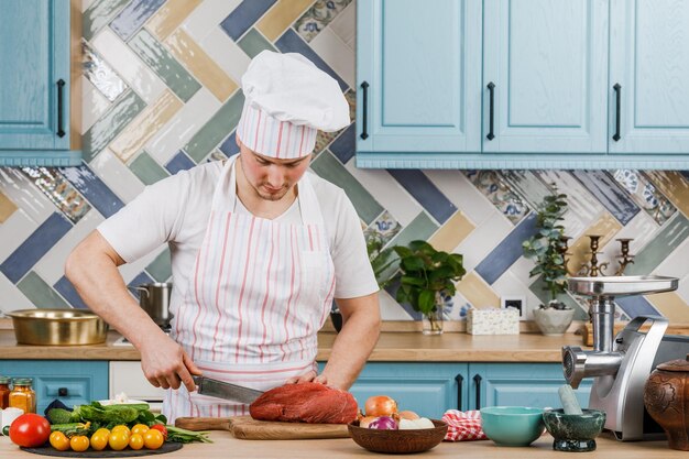 Joven prepara comida en casa en la cocina