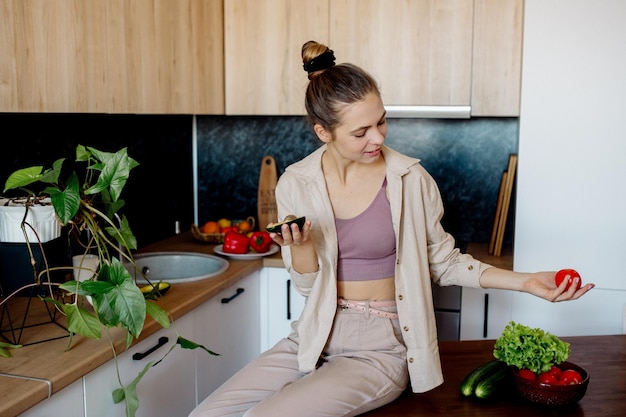 Una joven prepara ensalada de verduras en casa Cocina vegana