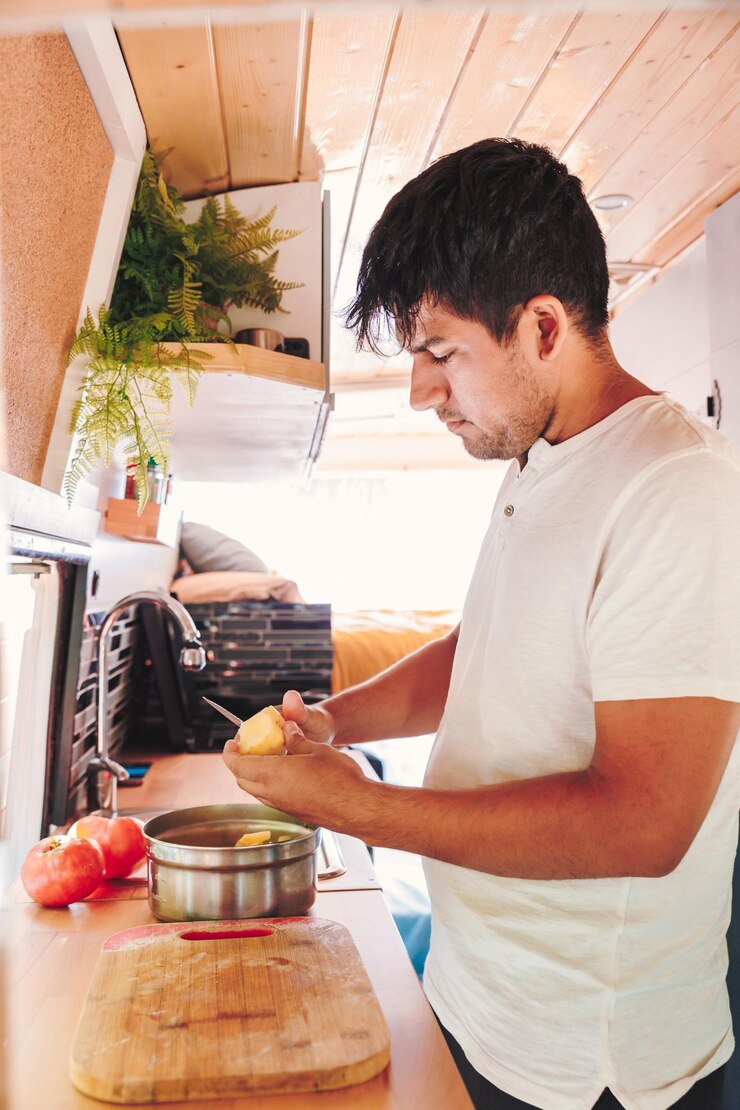 Foto joven preparando comida en la cocina de su autocaravana van viaje por carretera concepto de estilo de vida nómada