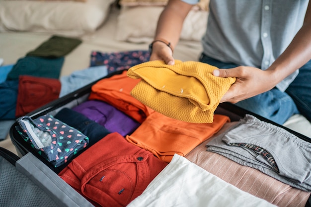 Joven preparando su ropa en la maleta