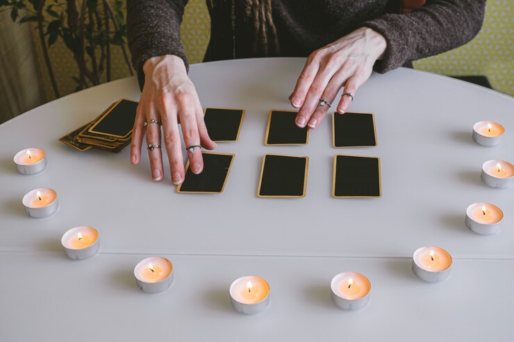 Foto joven presenta tarjetas negras sobre la mesa con luces de velas