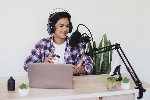 Joven presentador de radio asiático hablando durante el podcast