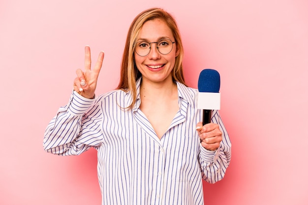 Joven presentadora de televisión caucásica mujer aislada sobre fondo rosa que muestra el número dos con los dedos