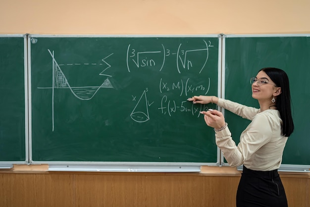 Joven profesor en el aula contra la pizarra