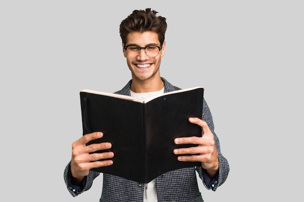 Joven profesor caucásico hombre sosteniendo un libro aislado