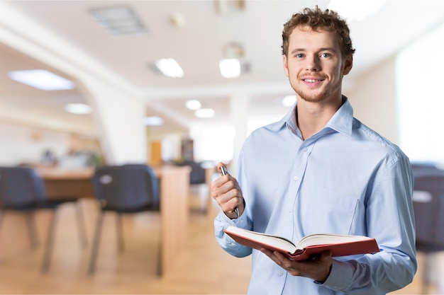 Joven profesor de pie con libro