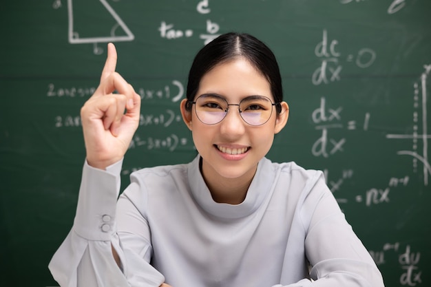 Joven profesora asiática mirando la videoconferencia de la cámara con el estudiante Profesora entrenando las matemáticas en el curso en línea del aula