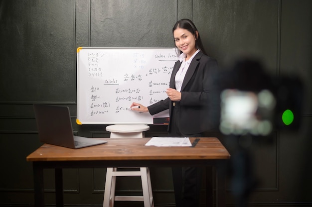 Una joven profesora está usando una cámara para grabar lecciones en línea durante la cuarentena, educación en línea, concepto de aprendizaje a distancia