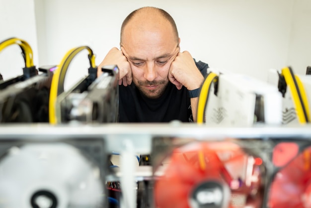 Joven programador ajustando la plataforma de minería de criptomonedas a una configuración operativa óptima. foto de alta calidad