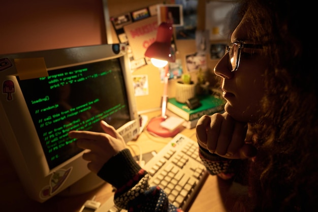 Joven programador trabajando en un ambiente acogedor de oficina en el hogar