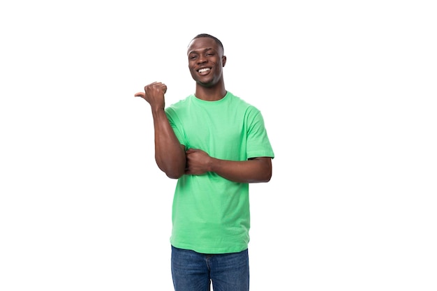 Joven promotor masculino estadounidense seguro de sí mismo con camiseta verde con maqueta