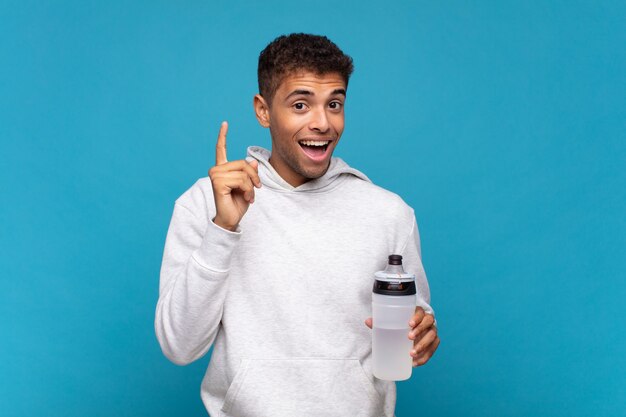 Joven que se siente como un genio feliz y emocionado después de darse cuenta de una idea, levantando el dedo alegremente