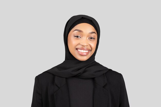 Una joven radiante con hijab y traje de negocios irradia confianza