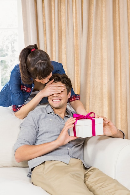 Joven recibe una caja de regalo sorpresa de una mujer joven en casa