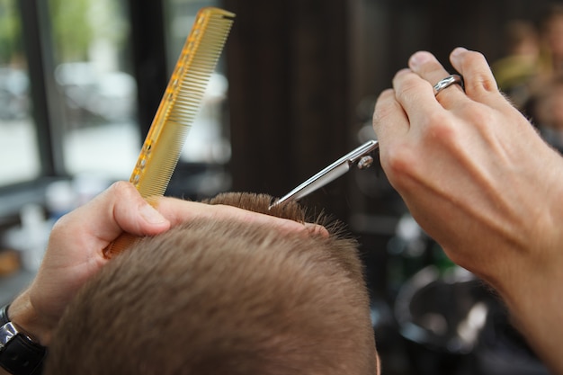 Joven recibiendo nuevo corte de pelo en la barbería