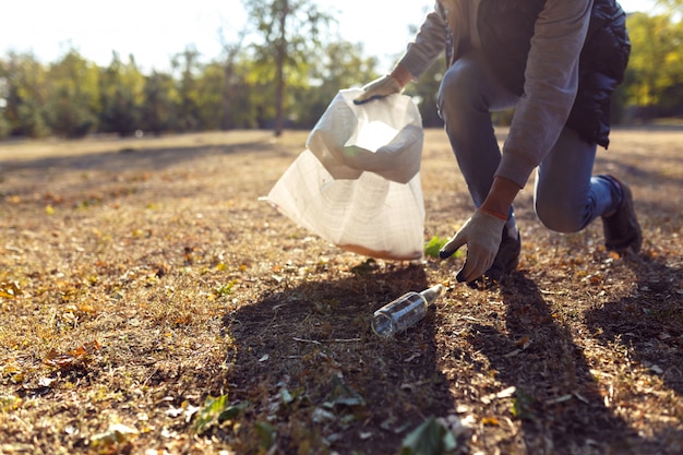 Foto joven recogiendo basura