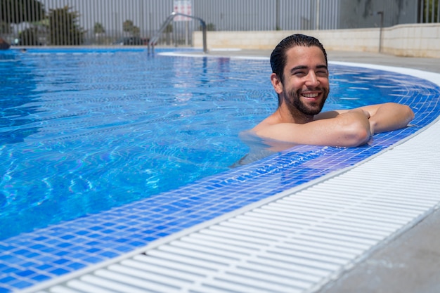 Joven relajado en la piscina