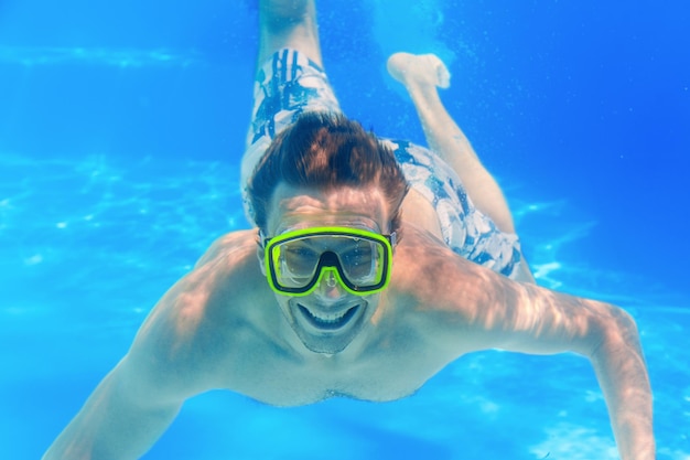 Joven relajarse en el agua azul de la piscina en verano