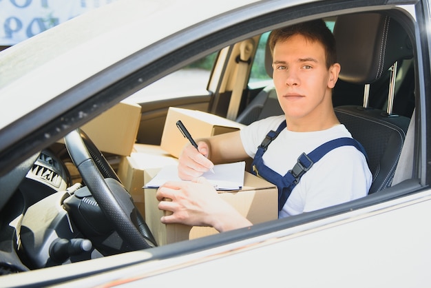 Foto joven repartidor lista de comprobación en el portapapeles en el coche