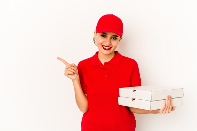 La joven repartidora de pizzas árabes flacas mira a un lado sonriente, alegre y agradable.