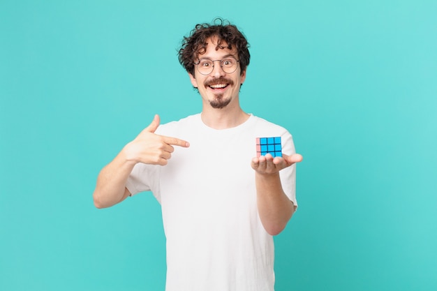 Joven resolviendo un problema de inteligencia sintiéndose feliz y apuntando a sí mismo con un emocionado