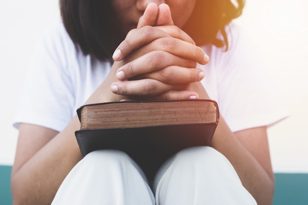 Foto joven rezando con la sagrada biblia